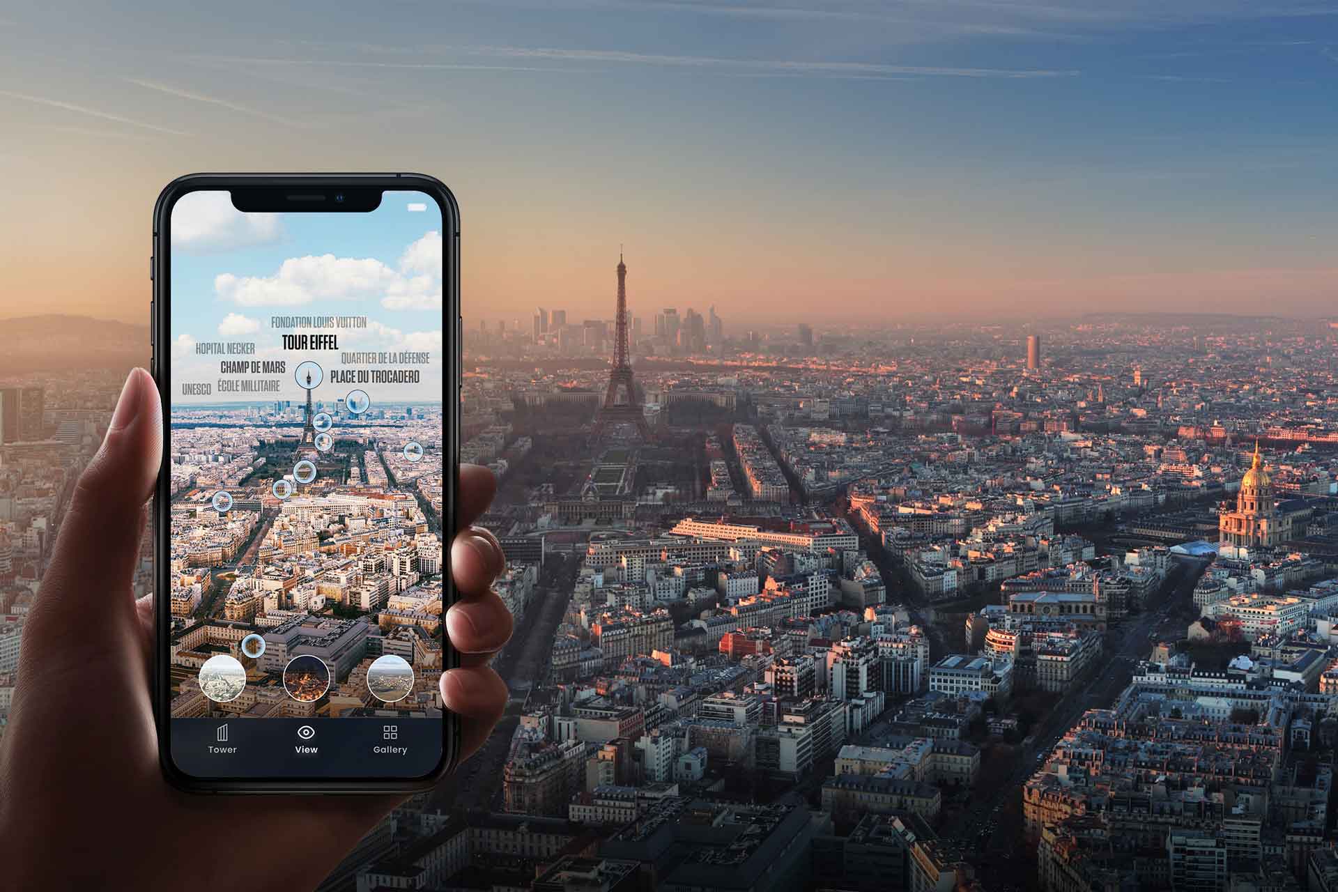 An image of a hand holding a cell phone in front of a skyline view of Paris