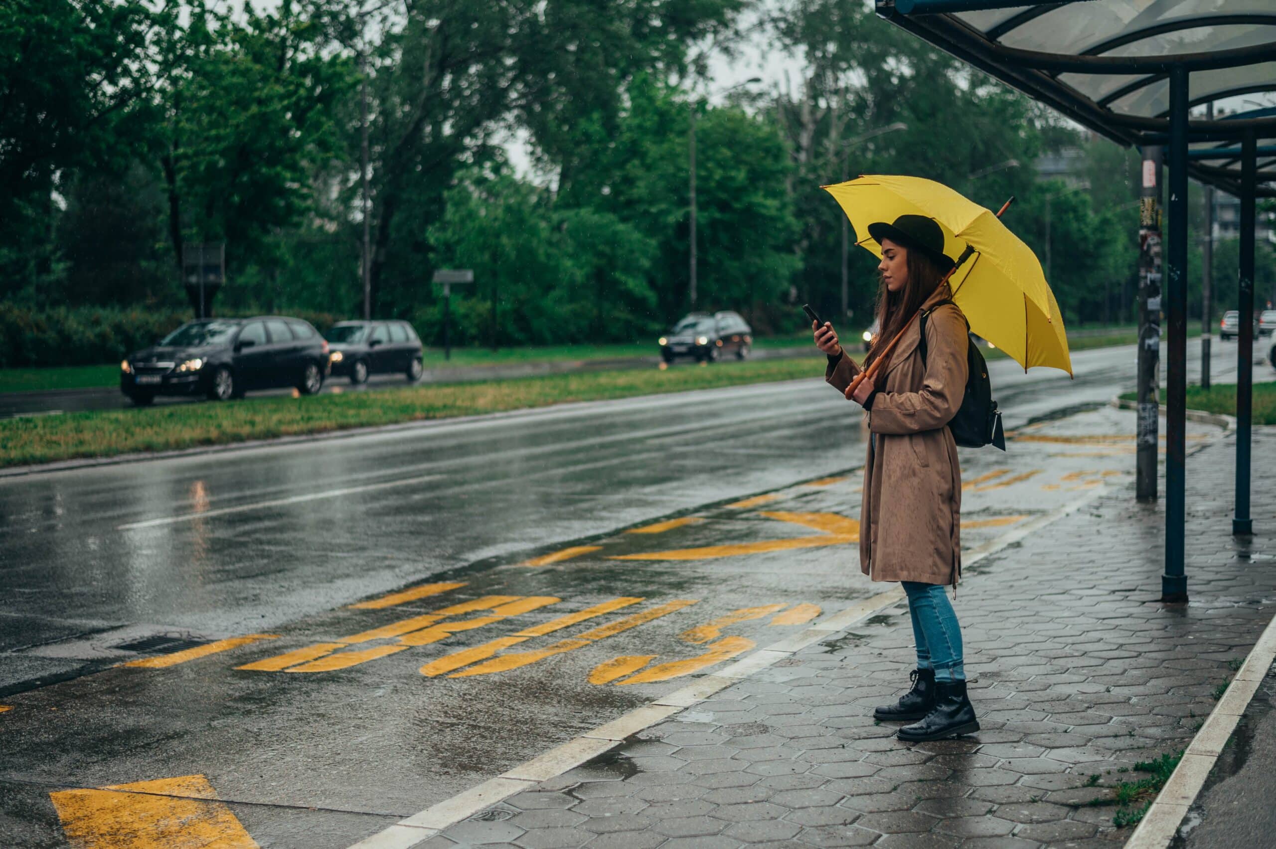 Une femme attend le bus sous la pluie