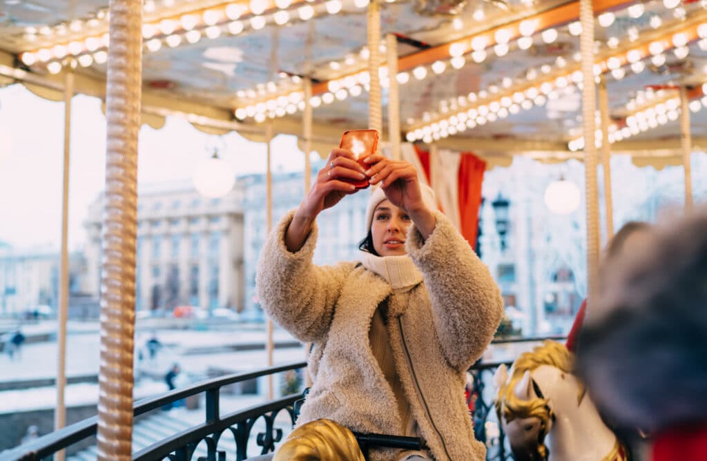 content woman on illuminated carousel taking shot 2025 03 31 06 25 41 utc