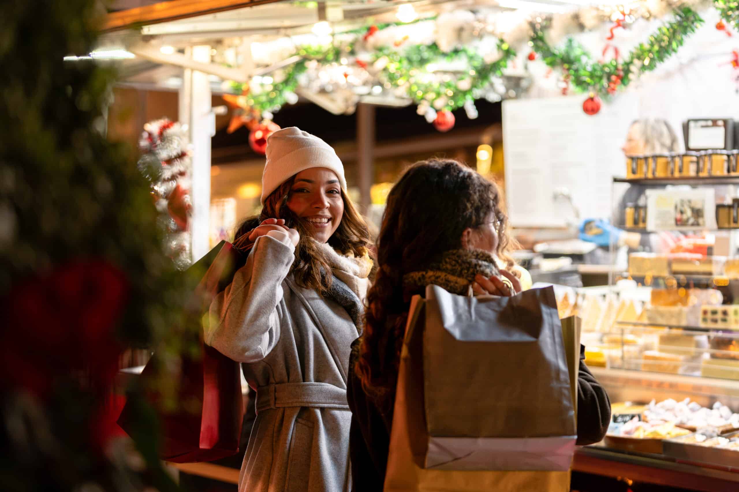 Women carrying shopping bags, enjoying festive atmosphere at night market